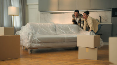 two people moving a modular sectional couch in their living room. 